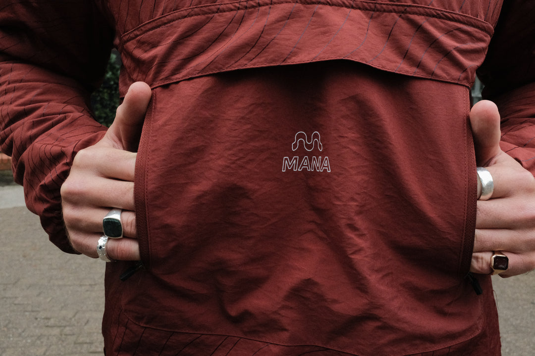 Close-up of a person wearing a red jacket with a visible brand logo on the chest.